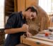 Woman in Blue Coveralls Using a Carpentry Tool
